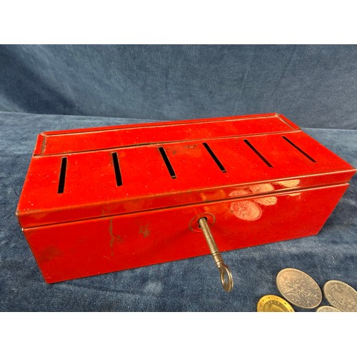 187 - A retro metal home savings thrift tin money box containing a quantity of coins from around the world... 
