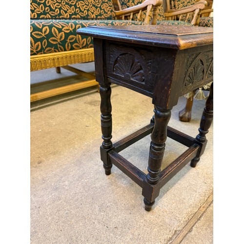 470 - A small carved oak stool/ side table with hinged top.