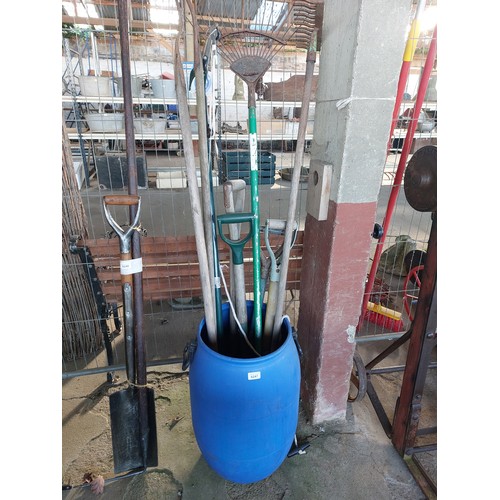 6247 - A blue water butt containing garden tools.