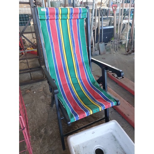 6253 - A black painted wooden framed deck chair with striped fabric.