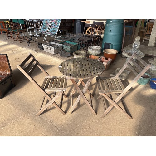 6411 - A teak wooden round table with 2 folding garden chairs.