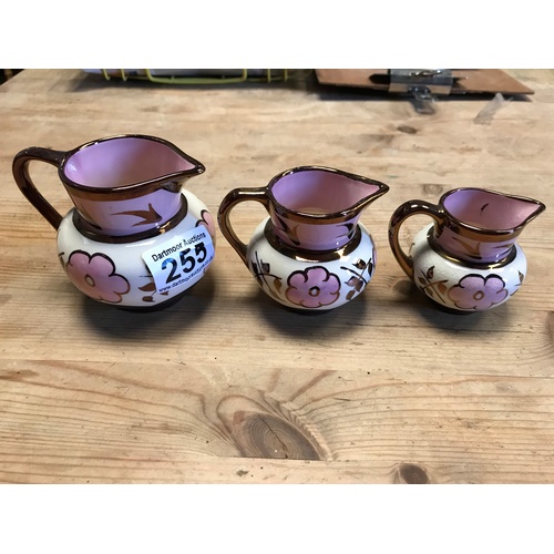 255 - Three graduating lustreware jugs
