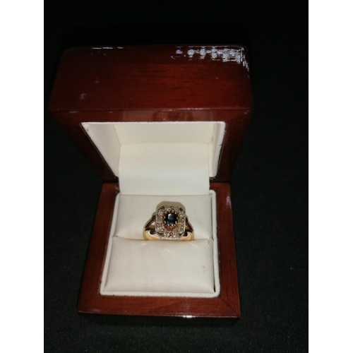 165 - A boxed old 9ct gold ring, sapphire surrounded by diamonds