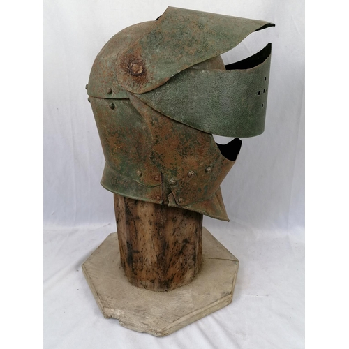 284 - An iron close helmet on a stand, some sixteenth century elements