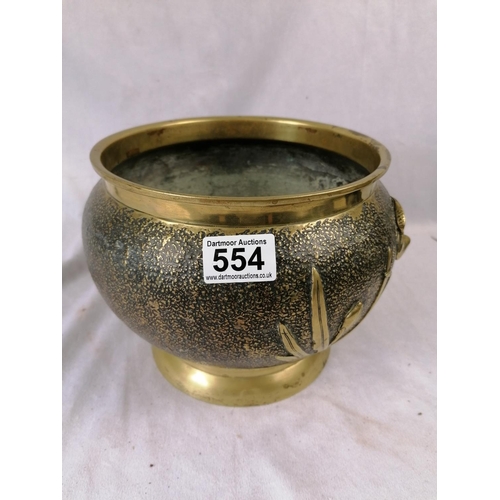 145 - An unusual 19C decorative brass plant pot cover/sleeve with hammered finish and raised floral decora... 