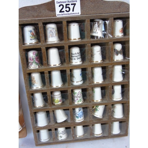 257 - A collection of 66 china collectors' thimbles in two wall racks