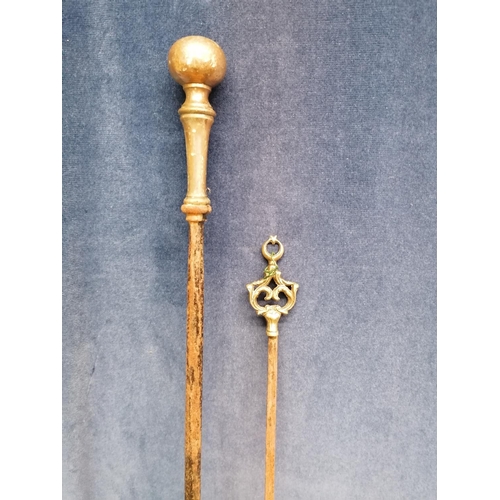 258 - An antique heavy iron fire poker with brass handle, 83cm and a long skewer with brass terminal