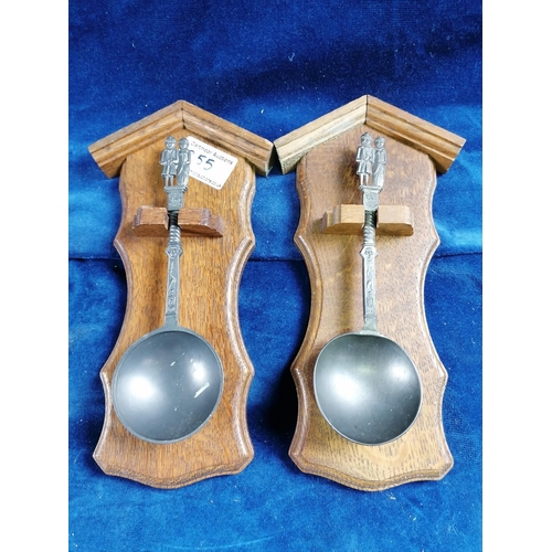 255 - A pair of pewter spoons mounted on oak plaques