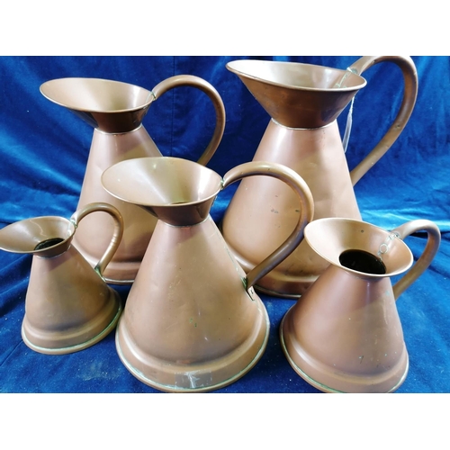256 - A set of five graduated copper jugs, the bell shaped bodies with loop handle