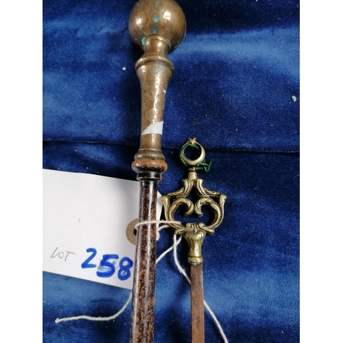 258 - An antique heavy iron fire poker with brass handle, 83cm and a long skewer with brass terminal