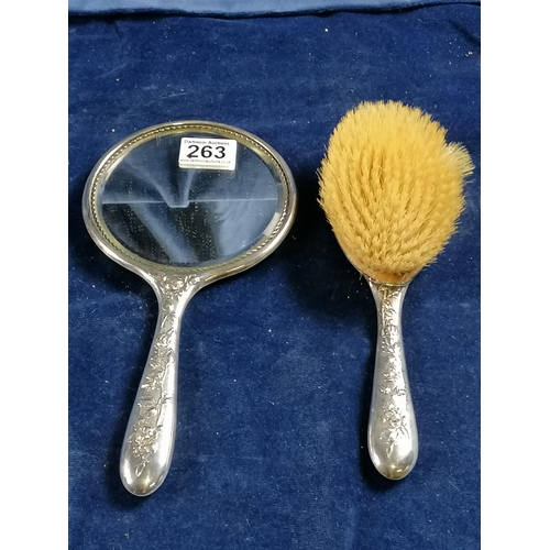 263 - A lady's hand mirror, the reverse and handle attractively embossed with trailing roses and also a ma... 