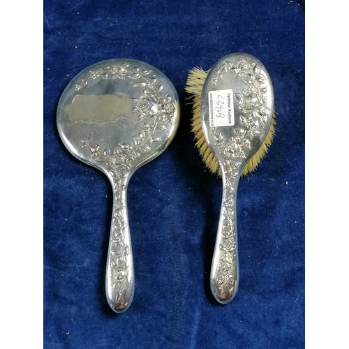 263 - A lady's hand mirror, the reverse and handle attractively embossed with trailing roses and also a ma... 