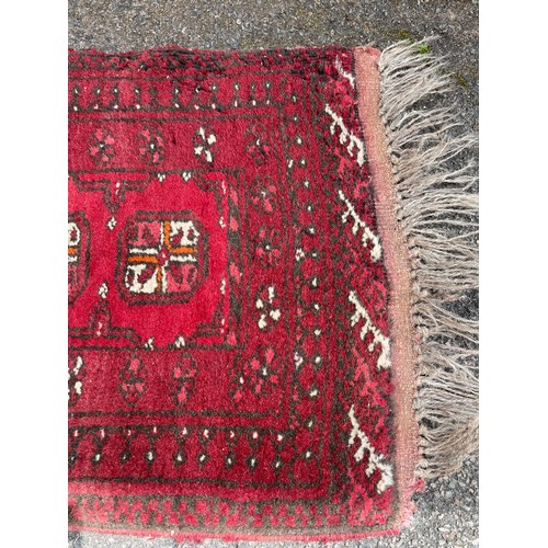 383 - A runner rug - patterned in red. Measures : 134 cm x 50 cm 0- in need of a good clean.