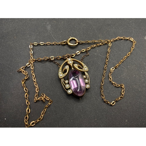 448 - Art Nouveau pearl and purple stone pendant on a metal chain. Large chip to stone