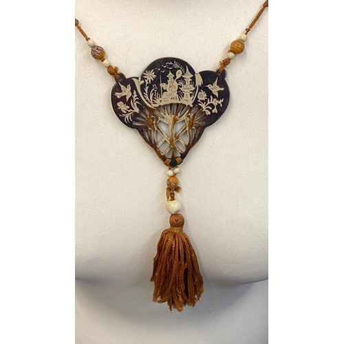 450C - An Art Deco long necklace with carved bone, handmade glass & horn beads
 threaded on silk, & hung wi... 