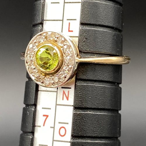 450F - Peridot and diamond circular “target” style cluster ring set in high carat gold