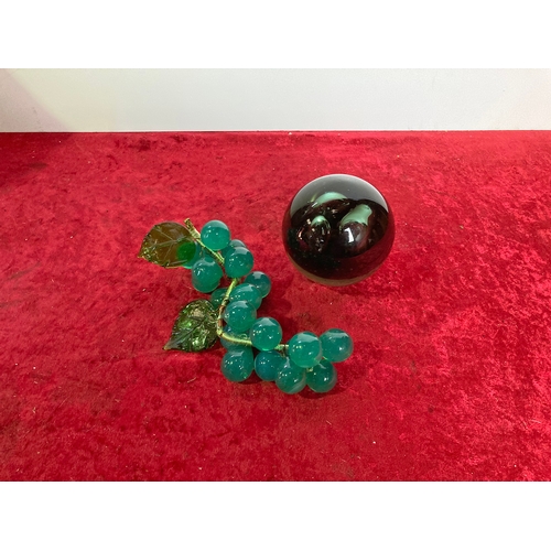 183 - A bag containing a large glass dump style paperweight and glass grape table decoration