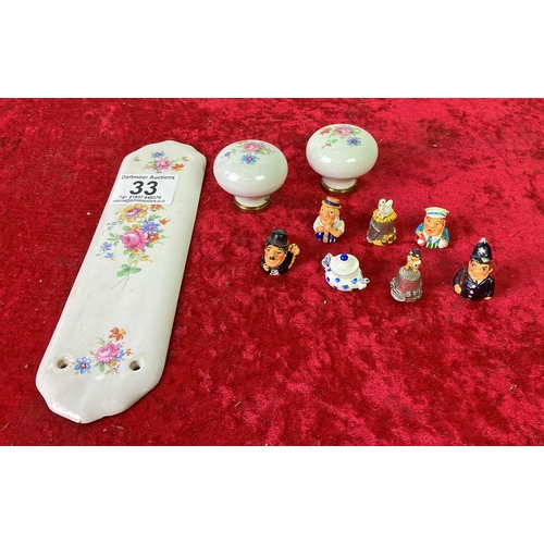 33 - 7 collectible china thimbles, porcelain door knobs and a matching finger plate