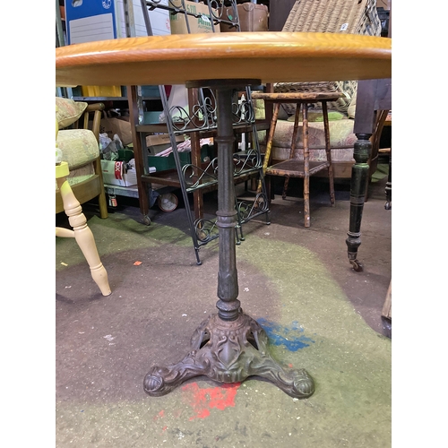 625 - A round pine topped table on an iron base with base decorative detailing , approx 30