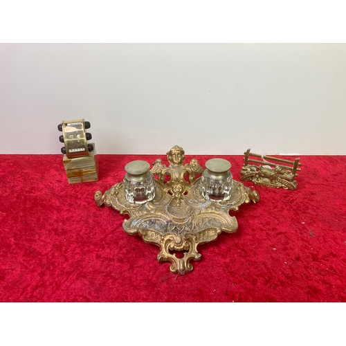 575 - A pretty collection of desk items. A gold coloured ink well stand and tray, a brass letter holder wi... 