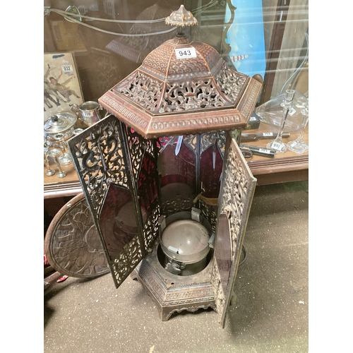 943 - A metal converted stove to lamp, very ornate, filigree markings. Measures approx 34 inches high