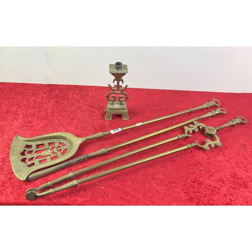 891 - Brass fireside tools and a candlestick