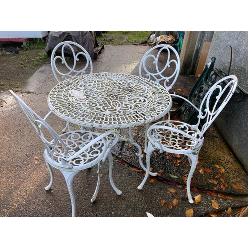 710 - Painted metal outdoor table (85cm diameter, 71cm tall) with four stylish chairs