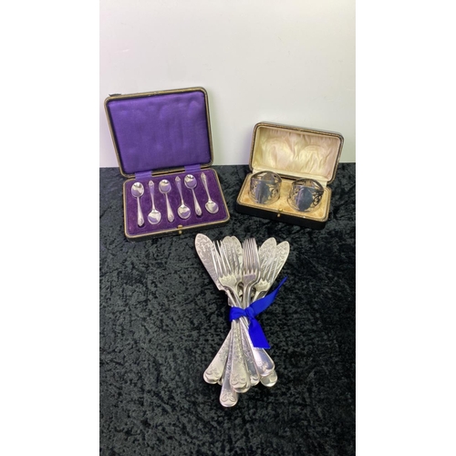 168 - A set of silver plated spoons along with a cased pair of silver plate napkin rings and a set of deco... 