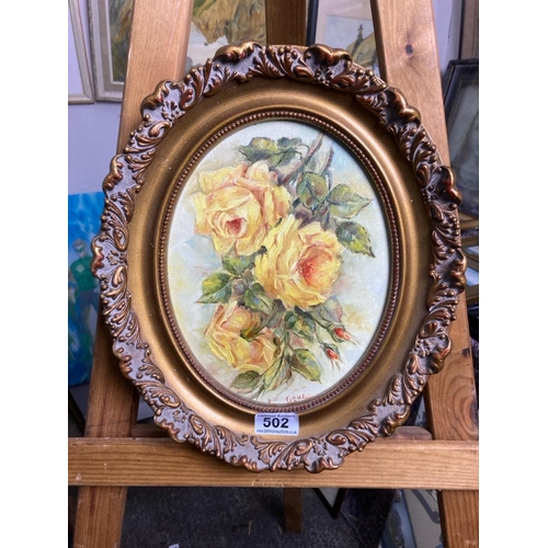 502 - Acrylic on board in a good oval gilt frame entitled ‘Roses’ by Irene E Lang. Approx 34cm x 30cm