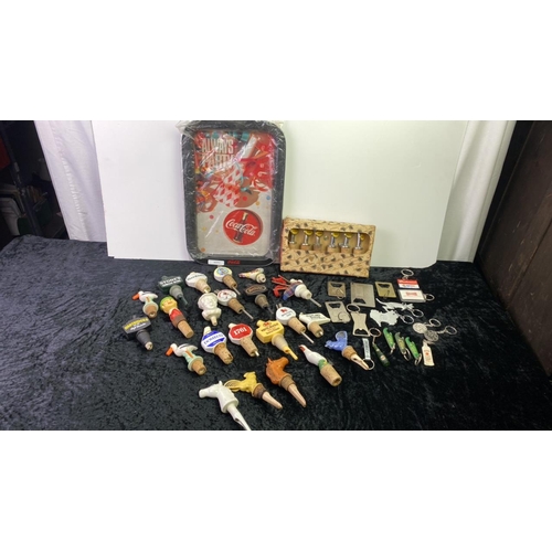 151 - A Coca Cola tray along with a collection of  decorative bottle stoppers, pourers and Breweriana key ... 