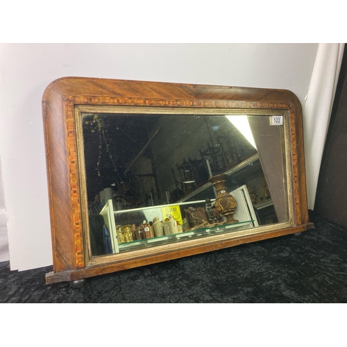 522 - A wooden framed overmantle mirror with marquetry detail. Marks to the mirror. Approx 43cm x 75cm