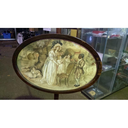 639 - Face fire screen with embroidered panel in oval frame (27cm x 36cm) on stand, approx 162cm tall.