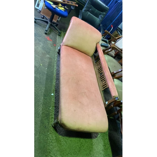 657 - Salmon pink upholstered chaise longue with carved wooden detail, approx 180cm x 75cm