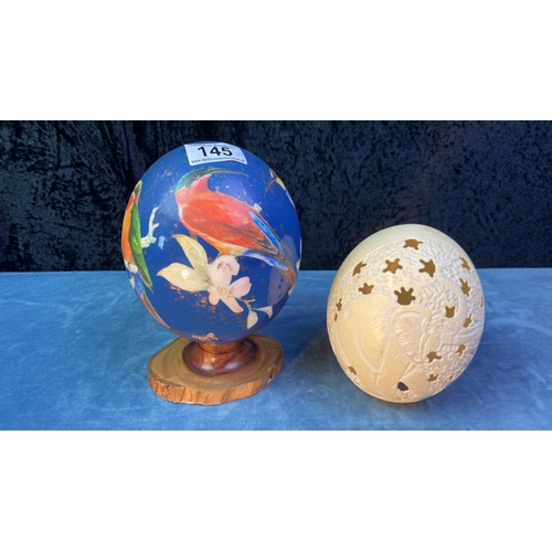 145 - Natural hand carved Ostrich egg along with a beautifully decorated  Ostrich egg on a wooden stand