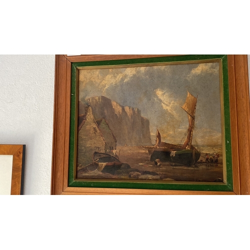 448 - A framed oil on canvas depicting a ship on beach scene, in wooden frame. Approx 42 cm x 50 cm