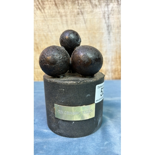 52 - Cast iron tin grinding balls mounted on a stone base with brass plaque, approx. 14 cm tall