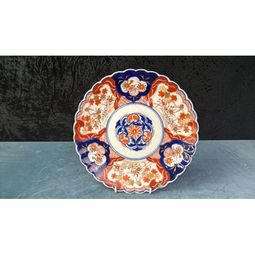 42 - Two hand painted Imari plates, diameters 21cm and 28cm (crack to larger plate)