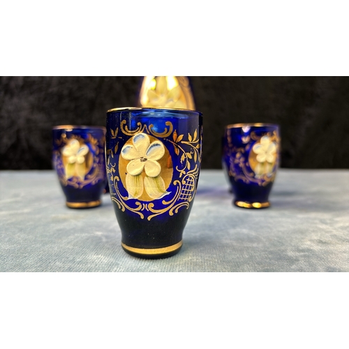 123 - Bohemian cobalt blue glass cordial decanter and 5 glasses, hand painted floral relief, with gold rim... 