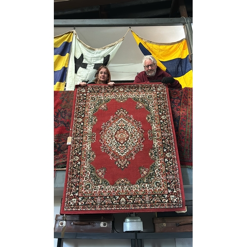 457 - Floor rug in red tones, measures approx 160cm x 122cm