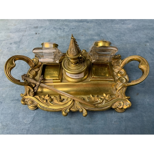 18 - Brass desk set with two glass inkwells, a brass sword letter opener and two brass stamp holders