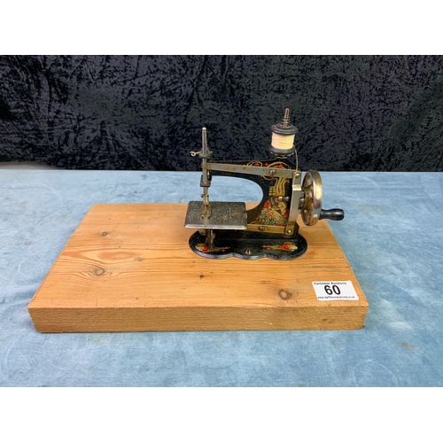 60 - Antique German miniature / child’s sewing machine, in working order, mounted in a wooden board