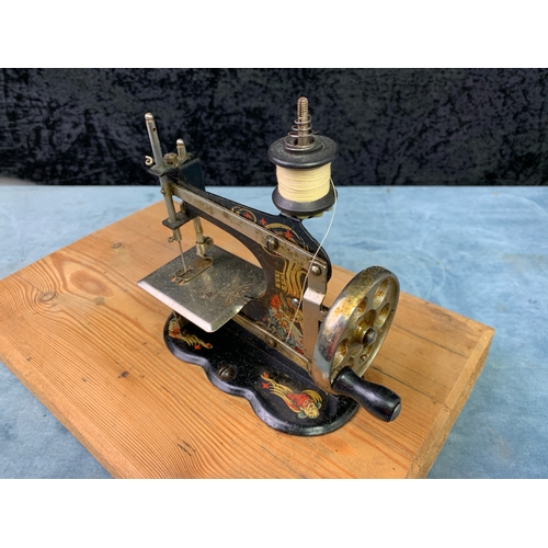 60 - Antique German miniature / child’s sewing machine, in working order, mounted in a wooden board