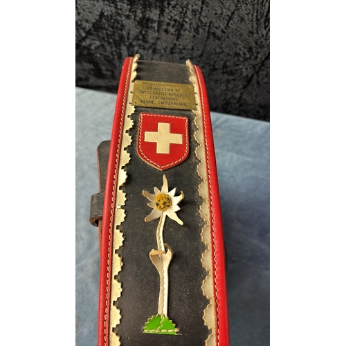 20 - Two very large brass cowbells on leather straps with embellishments depicting an Edelweiss flower an... 