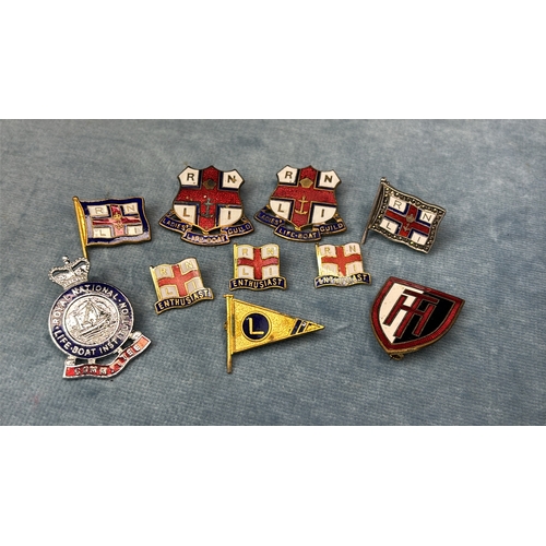 594 - Collection of metal and enamel RNLI badges along with a Dartmouth Yacht Club and an old school badge