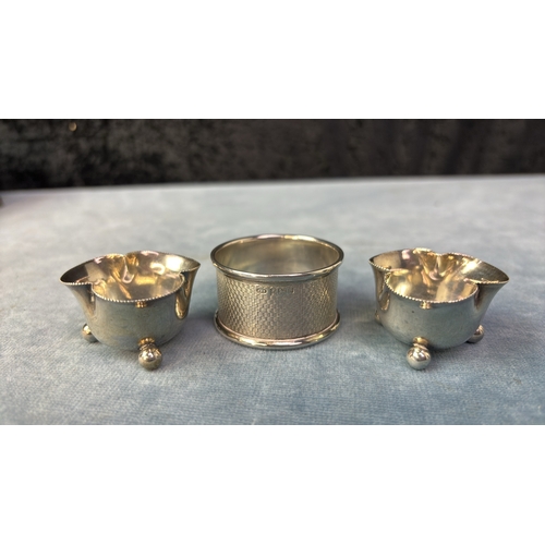 691 - A pretty little pair of clover leaf shaped salts London 1909 29 gms and an engine turned silver napk... 