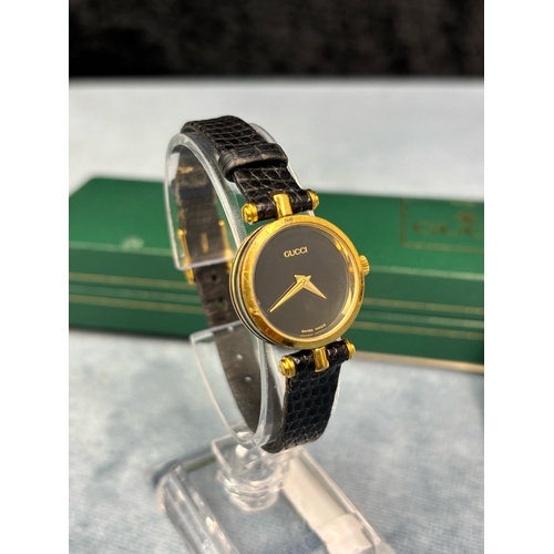 703 - Swiss made Gucci ladies black faced ladies watch with black leather strap.