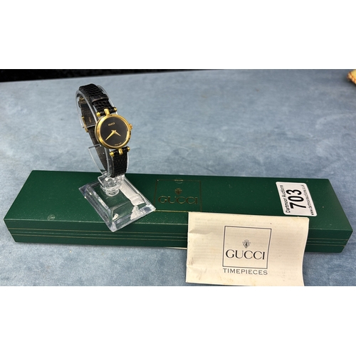 703 - Swiss made Gucci ladies black faced ladies watch with black leather strap.