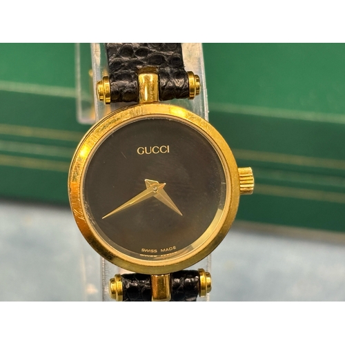 703 - Swiss made Gucci ladies black faced ladies watch with black leather strap.