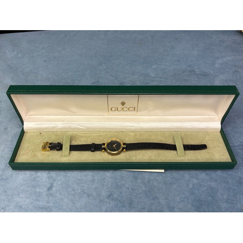 703 - Swiss made Gucci ladies black faced ladies watch with black leather strap.