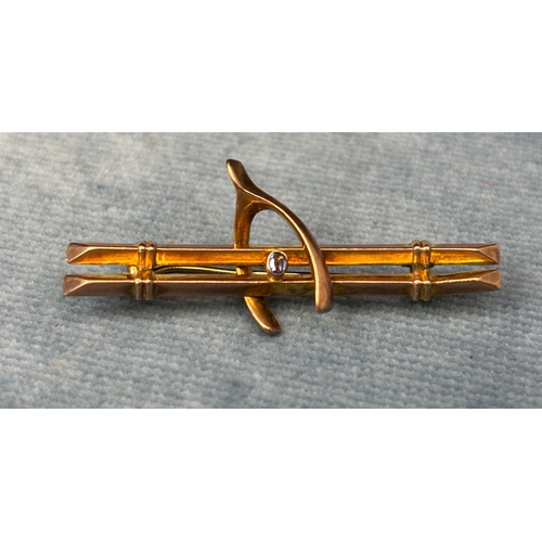 711 - Pretty vintage 9ct gold wishbone brooch inset with a pale blue gemstone. 2.13 gms.